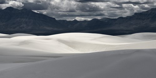 White Sands National Park (Nouveau Mexique, USA) - Jeux de lumière et d'ombre sur les dunes de sable blanc avec montagnes sombres en fond et ciel nuageux(VO-20-0419)