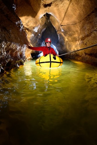 Grotte de la Vieille Folle (Doubs) - Spéléo traversant le petit lac en canot (personnage éclairé)(SP-20-0719)