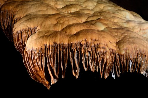 Grotte d'Orquette (Hérault) - Grande coulée de calcite orange avec petites draperies (SP-20-1150)