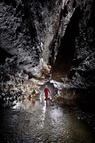 Baume de Gonvillars (Doubs) - Rivière coulant dans une grande diaclase (spéléo en fond en contre-jour)(SP-21-1230)