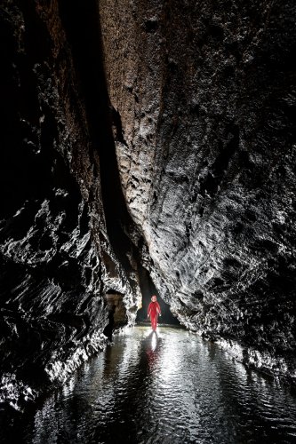 Baume de Gonvillars (Doubs) - Rivière coulant dans une large galerie (spéléo en fond en contre-jour)(SP-21-1221)