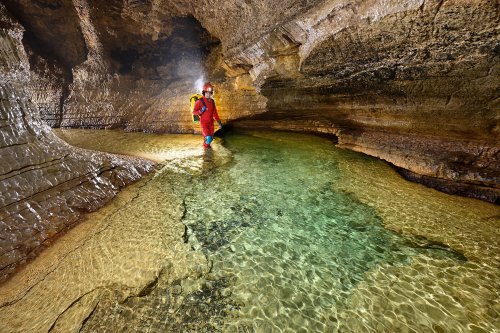 Grotte de Bouzic (Dordogne) - Progression dans la rivière avec l'eau verte et les dépôts de calcite jaune (SP-22-0859)