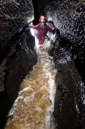 Cullaun Two (Burren, Irlande) - Spéléo remontant la rivière souterraine aux eaux tourbeuses(SP-22-1919)