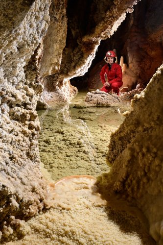Grotte de la Douch (Hérault) - Galerie avec sol cristallisé et gour d'eau verte (spéléo en arrière plan)(SP-23-0091)