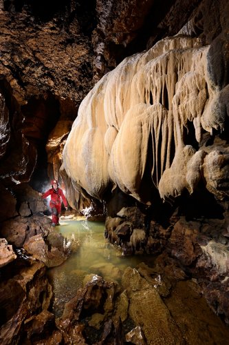 Grotte de Foissac (Aveyron) - Grande coulée de calcite blanche au dessus de la rivière(SP-23-0641)