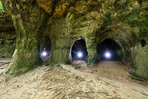 Gruta Palacio (Amazonas, Brésil) -  Trois personnages  sous les arches d'entrée de la grotte (avec flashs dirigés vers l'appareil)(SP-23-1067)