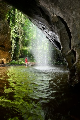 Caverna das Maos (Para, Brésil) - Cascade près de l'entrée de la grotte avec spéléo en fond et vasque d'eau en premier plan(SP-23-1241)
