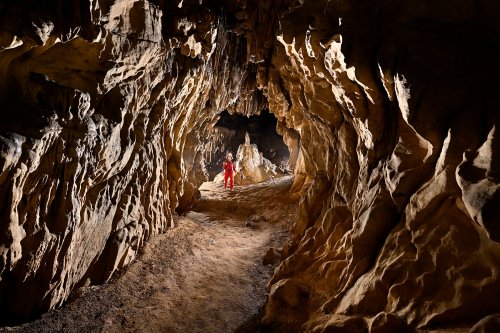 Grotte de Tham Long Yaow (province de Mae Hong Son, Thaïlande) - Galerie circulaire en contre jour avec spéléo en fond(SP-24-0471)