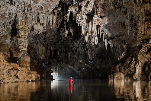 Grotte de Tham Lod (province de Mae Hong Son, Thaïlande) - Spéléo dans l'eau vers la sortie devant une colonne et des stalactites (SP-24-0569)