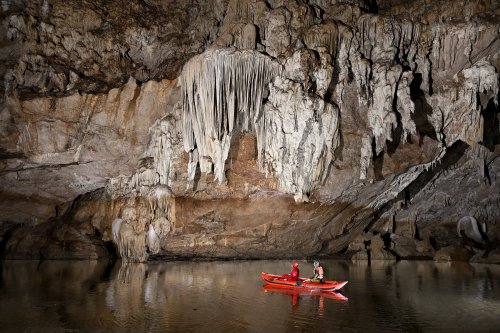 Grotte de Tham Lod (province de Mae Hong Son, Thaïlande) - Spéléos dans un kayak devant ensemble de concrétions sur une paroi (SP-24-0266)