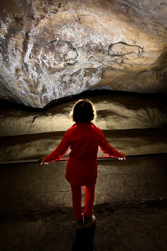Grotte de Niaux (Ariège) - Salon noir : touriste  devant le premier panneau de peintures pariétales(SP-24-0871)