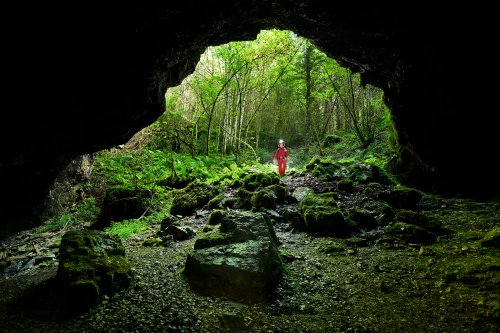 Grotte du Fourneau de Guémande (Doubs) - Entrée de la grotte vue de l'intérieur (avec personnage)(SP-24-2301)