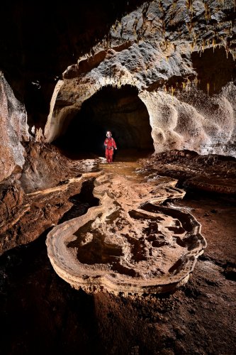 Grotte de Saint-Marcel d'Ardèche (réseau I) - Gour à sec avec table de calcite (spéléo en arrière plan)(SP-24-2478)
