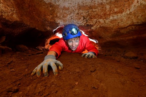 Grotte de Saint-Marcel d'Ardèche (réseau I) - Ado rampant dans un passage bas (horizontale)(SP-24-2160)