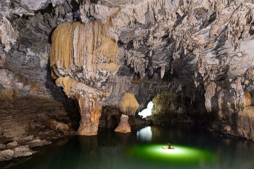 Hang Ken cave (Tan Hoa, Vietnam) - Navigation sur la rivière avec piliers concrétionnés massifs sur le côté (eau éclairée)(SP-25-0257)