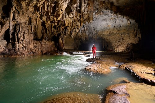 Hang Kim cave (Tan Hoa, Vietnam) - Rivière aux eaux vertes avec spéléo à côté petit rapide (horizontale)(SP-25-0202)