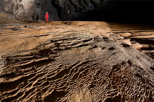 Hang Va cave (Phong Nha, Vietnam) - Ensemble de petits gours secs en escalier (spéléo en fond)(SP-25-0332)