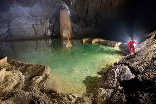 Hang Va cave (Phong Nha, Vietnam) - Grand gour rempli d'eau verte avec spéléo sur une vire sur le côté(SP-25-0405)