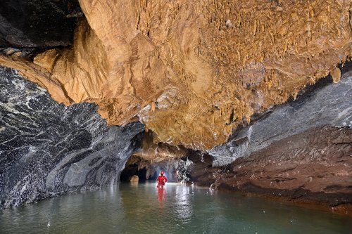 Hang Va cave (Phong Nha, Vietnam) - Rivière souterraine dans une galerie au plafond couvert de calcite orange(SP-25-0374)
