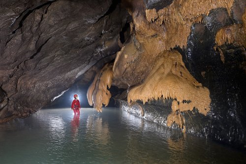 Hang Va cave (Phong Nha, Vietnam) - Rivière souterraine dans une galerie avec coulées de calcite orange sur les parois(SP-25-0376)