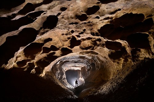 Grotte de la Douch (Courniou, Hérault) - Galerie finale avec un personnage en silhouette et en contre-jour en fond.(SP-25-0662-A)