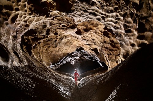 Grotte de la Douch (Courniou, Hérault) - Galerie finale avec personnage au centre et talus d'argile sur les côtés. .(SP-25-0677)