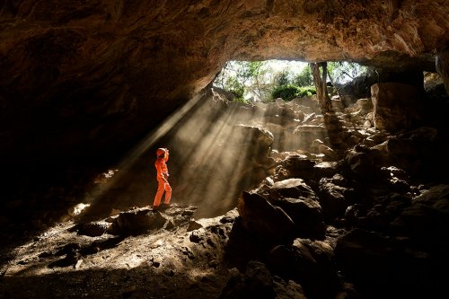 Gcwihaba cave entrée nord (Botswana) - Rayons de soleil pénétrant dans l'entrée (avec spéléo en bas)(SP-25-0865)