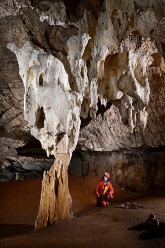 Gcwihaba cave (Botswana) - Concrétions corrodées (avec spéléo assis en fond)(SP-25-0847)
