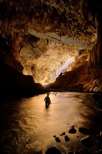 Lapa Terra Ronca (Goias, Brésil) - Spéléo dans la rivière avec salle éclairée par un rayon de soleil en fond (spéléo en silhouette)(SP-25-1896)