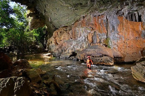 Lapa Terra Ronca (Goias, Brésil) - Passage sous une arche naturelle avec coulées de calcite et spéléo dans la rivière entre Terra Ronca 1 et 2.(SP-25-1818)