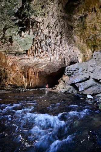 Lapa Terra Ronca (Goias, Brésil) - Porche de sortie de Terra Ronca 1 vu de l'extérieur avec spéléo dans la rivière.(SP-25-1464)