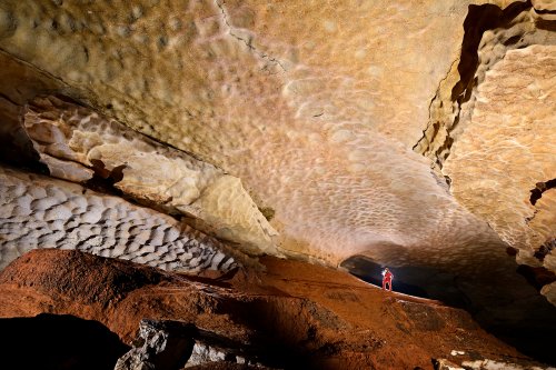 Grotte de Saint-Marcel d'Ardèche (partie touristique) - Galerie avec remplissage argileux et coups de gouge sur la paroi (spéléo en arrière plan)(SP-25-1306)