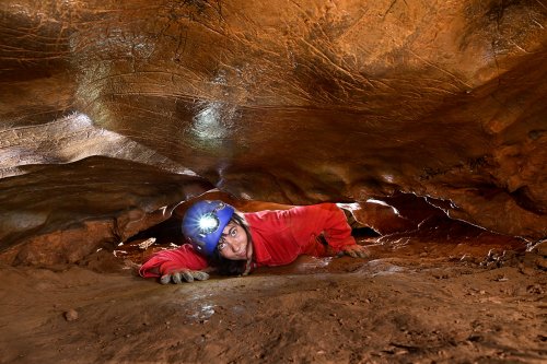 Grotte des Claris (Gard) - Spéléo rampant dans un passage étroit(SP-25-2368)