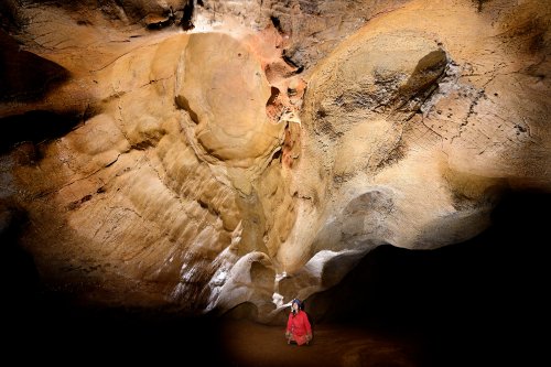 Grotte des Claris (Gard) - Deux coupoles au plafond d'une galerie : les chauves-souris ont corrodé celle de droite, alors que celle de gauche est préservée (vue ensemble avec spéléo assis)(SP-25-2361.jpg)