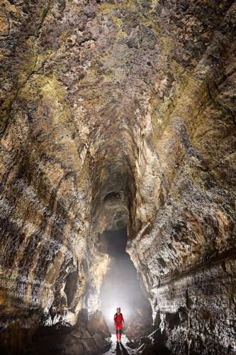 Tunel Primicias (Santa Cruz, Galapagos, Equateur) - Haute galerie avec traces d'écoulement de la lave envahie par le brouillard (personnage éclairé)(SP-26-0108)