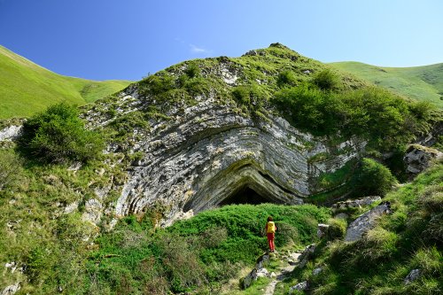 Grotte d'Harpéa (Pyrénées-Atlantiques) - Vue de la grotte avec personnage devant (avec ciel) (HY-25-0091)