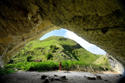 Grotte d'Harpéa (Pyrénées-Atlantiques) - Vue vers l'extérieur depuis l'intérieur de la grotte avec personnage dans l'entrée (plafond éclairé)(HY-25-0122)