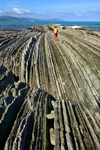 Flysch de Zumaia (Espagne) - flysch sur la plage d'Itzurun : vue vers la mer (avec personnage)(HY-25-0182)