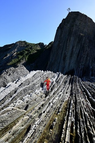 Flysch de Zumaia (Espagne) - Vue du flysch sur la plage d'Itzurun avec montagne  à l'ombre en arrière plan (avec personnage de face)(HY-25-0197)