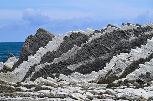 Flysch de Zumaia (Espagne) - Vue du flysch sur la plage d'Itzurun : alternance de chevrons blancs et gris (avec ciel et sans personnage)(HY-25-0221)