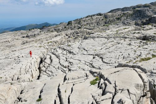 Arres d'Anie (Pierre Saint-Martin, Pyrénées Atlantiques) - Vue d'ensemble des dalles du lapiaz avec personnage(MO-21-0076)