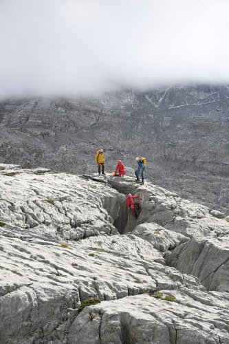 Arres d'Anie (Pierre Saint-Martin, Pyrénées Atlantiques) - Groupe de spéléos équipant un gouffre (lapiaz au soleil)(MO-25-0075)