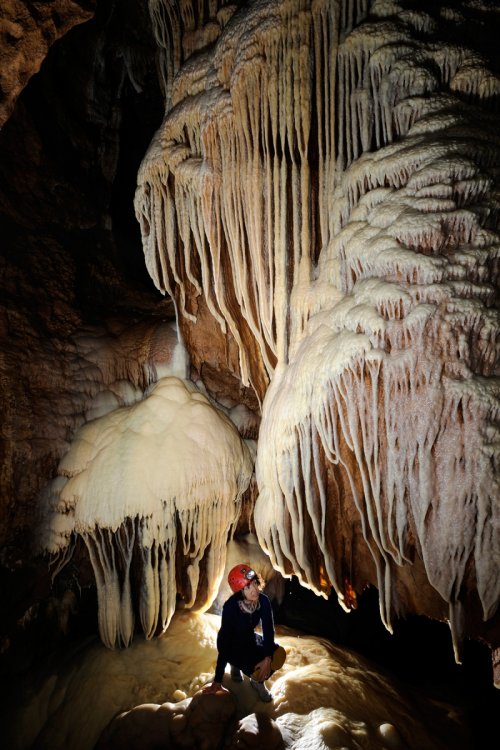 Grotte des Vents d'Anges (Aude) : Femme au pied de coulées de calcite blanche et de draperies(SP-08-0734)