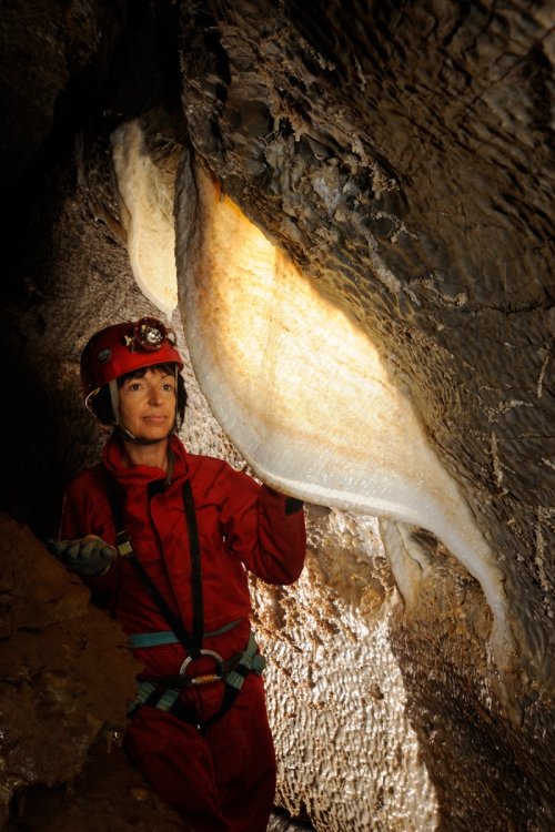 Grotte de l'Ascension (Hérault) - Spéléo devant draperie blanche translucide dans galerie(SP-10-0581)