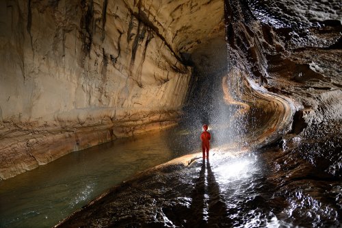 Clearwater Cave (Gunung Mulu National Park, Bornéo, Malaisie) - Rivière et  personnage derrière une cascatelle tombant du plafond. (SP-13-0621)