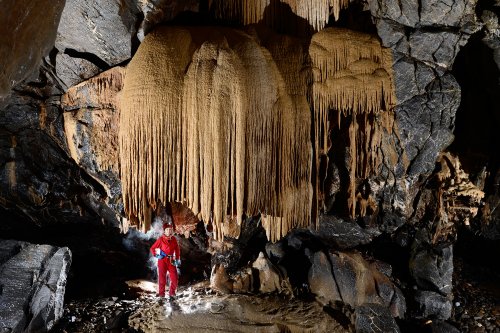 Stara Amaterska Cave (Tchéquie, Moravie, Parc National de Podiji) - Galerie avec coulée de calcite et spéléo.(SP-13-0856)