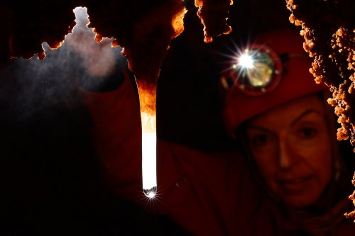 Grotta del Paranco (région de Trieste, Italie) - Spéléo regardant une fistuleuse blanche avec goutte(SP-13-0919)