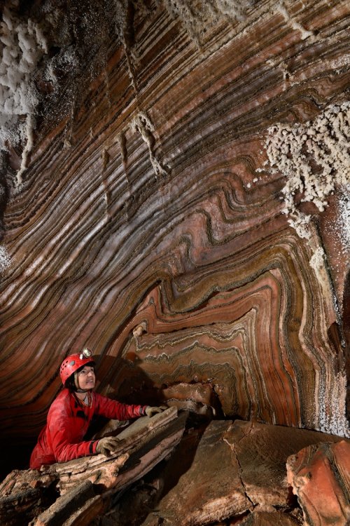 Cueva de Forat Mico (Espagne) : spéléo devant des plis dans les strates de sel colorées sur la paroi d'une galerie(SP-17-0174)