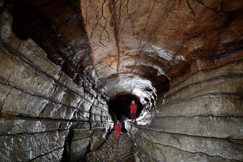 Réseau inférieur de la Cocalière - Galerie en trou de serrure avec deux spéléologues, l'un à droite dans la partie syngénétique (conduite forcée initiale), l'autre, à gauche, dans la partie paragénétique (érosion en écoulement libre).(SP-17-0826)