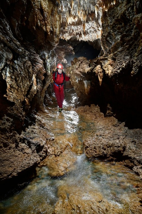Grotte d'Orquette (Plateau d'Albès, Hérault) - Spéléo progressant dans la rivière souterraine avec un petit rapide en premier plan(SP-17-1761)